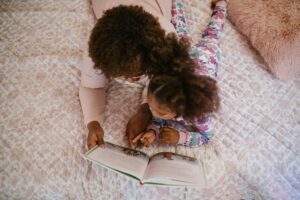 woman reading to daughter in bed